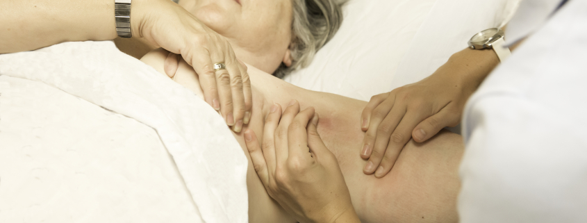 Woman lying on a bed receiving treatment for her arm lymphedema